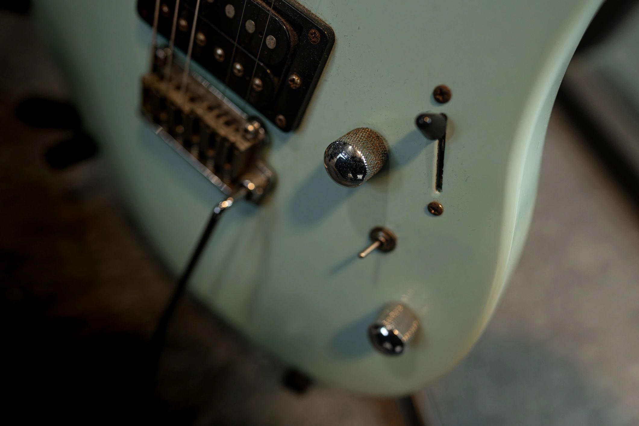 Close-up of an electric guitar showing pickups and controls